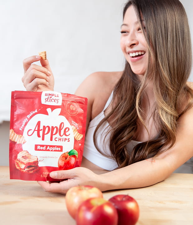 Woman smiling and eating Simple Slices Apple Chips